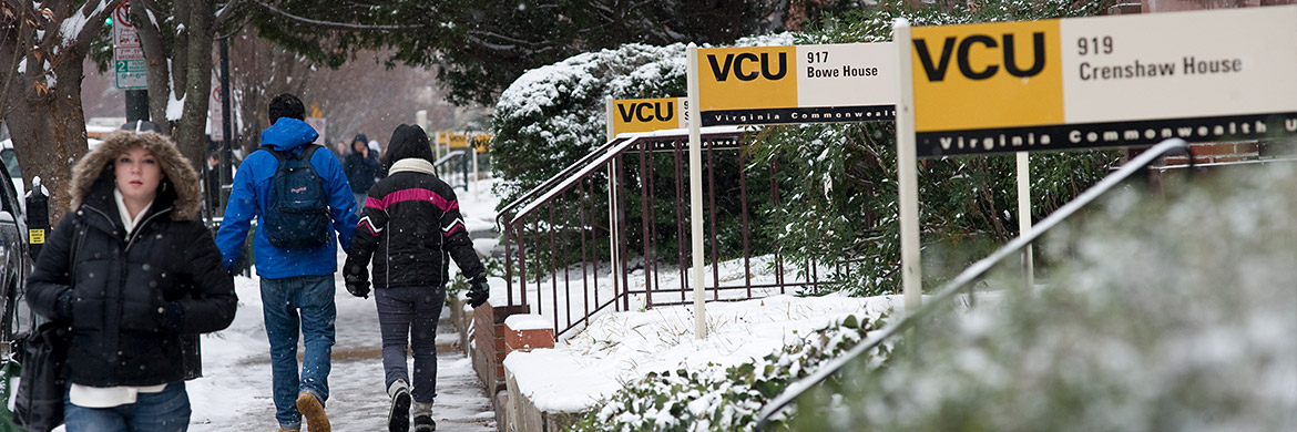 Students walking down sidewalk with snow on the ground